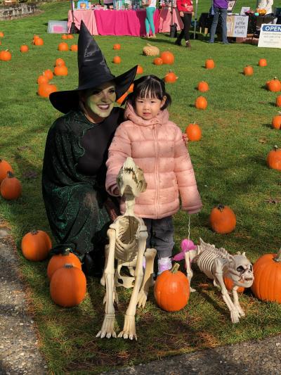 KDA event manager in witch costume with young kid