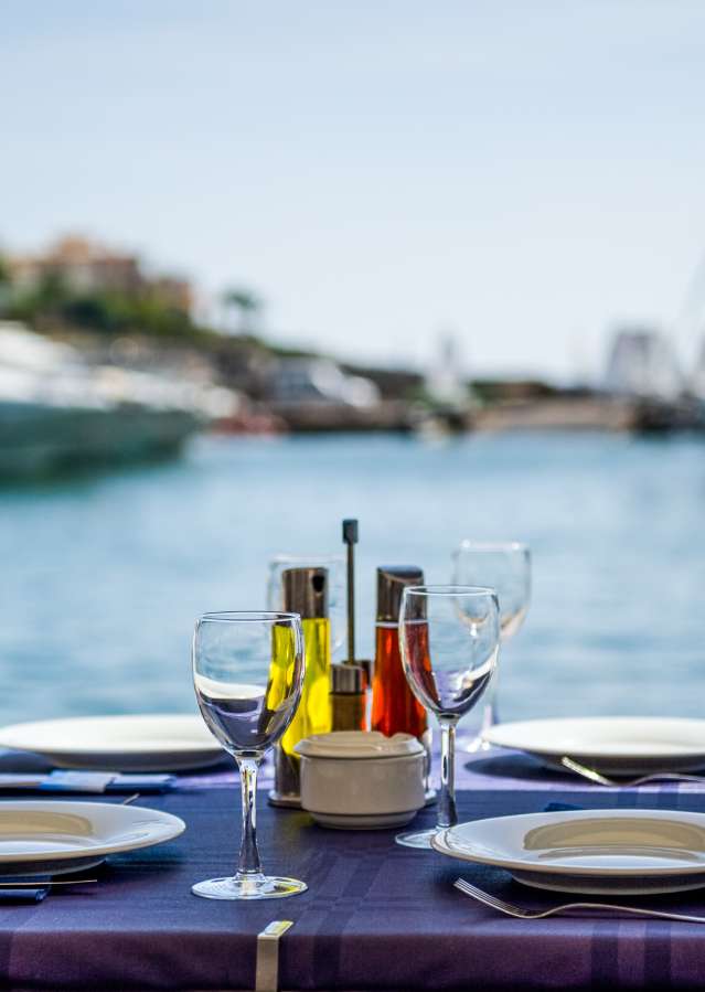 Patio dining table with wine glasses and boats